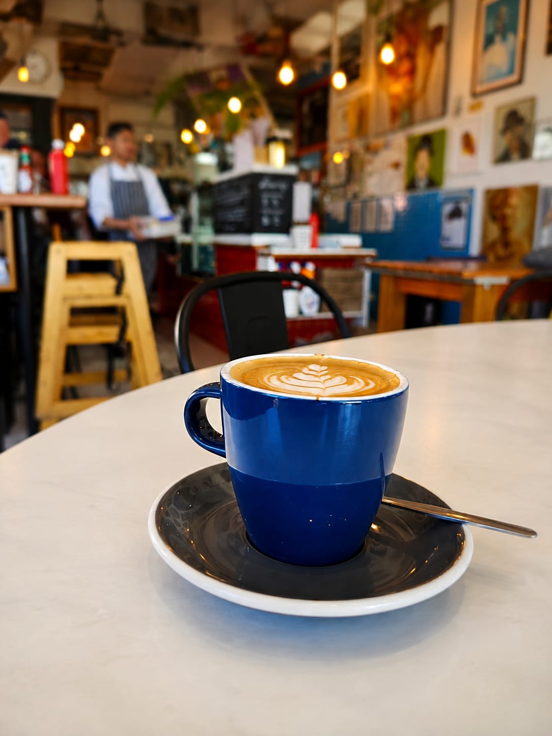 A blue latte cup in Belle's art-filled cafe