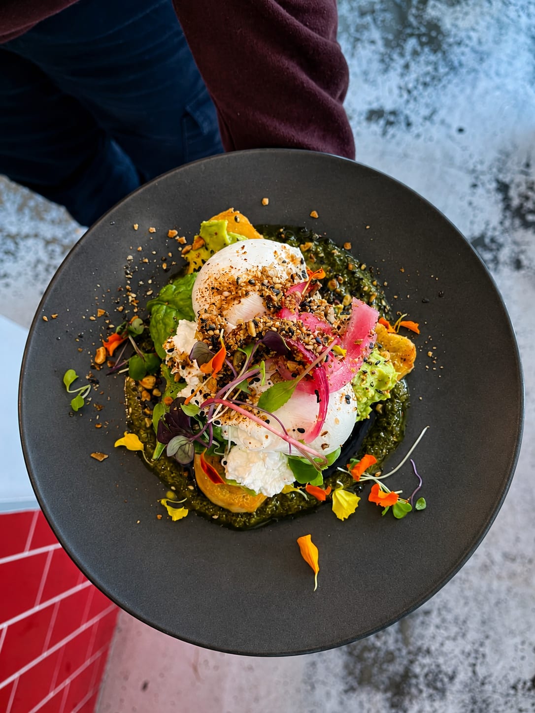 A Belle breakfast plate with poached eggs, greens and colourful pickles