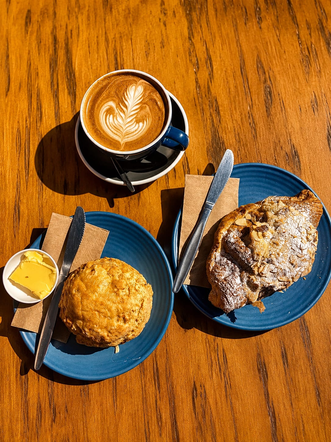 Belle pastries and coffee on blue plates at a timber table